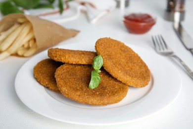 Delicious fried breaded cutlets served on white table, closeup