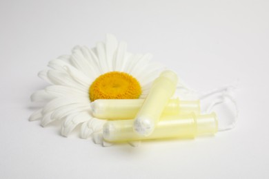 Applicator tampons and chamomile flower on white background. Menstrual hygiene product