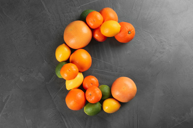 Letter C made with citrus fruits on grey table as vitamin representation, flat lay
