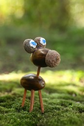 Photo of Cute figure made of acorns on green moss outdoors,