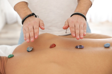 Man during crystal healing session in therapy room, closeup