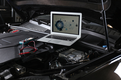 Laptop with diagram on auto engine. Modern car diagnostic