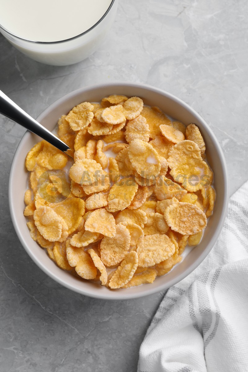 Tasty cornflakes with milk served on grey marble table, flat lay