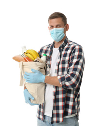 Male volunteer in protective mask and gloves with products on white background. Aid during coronavirus quarantine