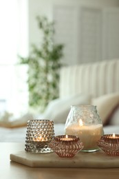 Photo of Set of scented candles on wooden table in room