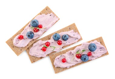 Tasty cracker sandwiches with cream cheese, blueberries, red currants and thyme on white background, top view