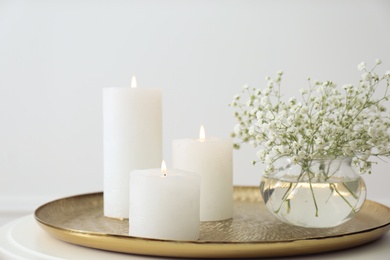 Vase with beautiful flowers and burning candles on table indoors. Interior elements
