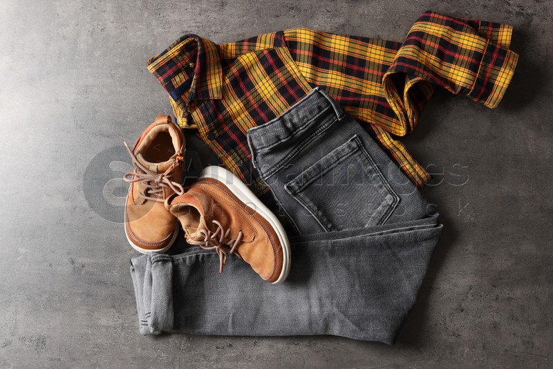 Stylish child clothes and shoes on grey background, flat lay