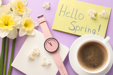 Flat lay composition with words HELLO SPRING, coffee, wristwatch and fresh flowers on violet background