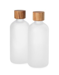 New empty glass bottles with wooden caps isolated on white
