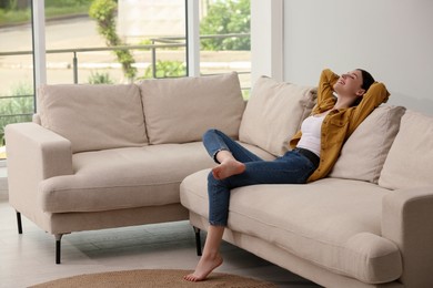 Teenage girl relaxing on sofa at home