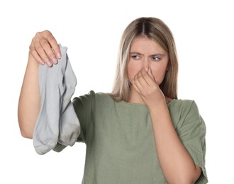 Photo of Young woman feeling bad smell from dirty socks isolated on white