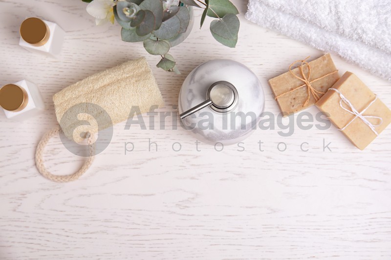 Flat lay composition with marble soap dispenser on white wooden background. Space for text