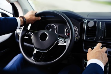 Man driving his car, closeup view of hands on steering wheel