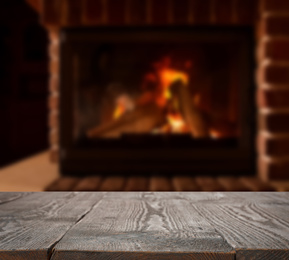 Rustic table and fireplace with burning wood indoors