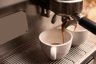 Preparing fresh aromatic coffee using modern machine, closeup. Space for text