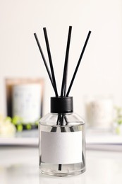 Aromatic reed air freshener on white table, closeup