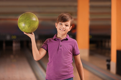 Preteen boy with ball in bowling club
