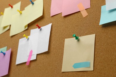 Colorful paper notes pinned to cork board, closeup