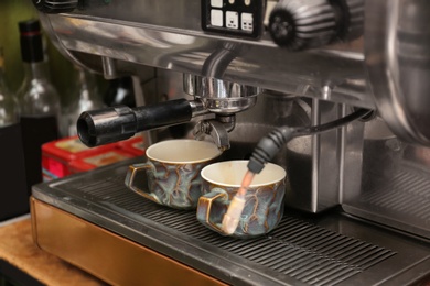 Preparing fresh aromatic coffee using modern machine at cafe