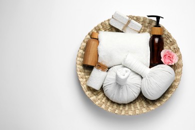 Beautiful spa composition with herbal massage bags and different care products on white background, top view. Space for text