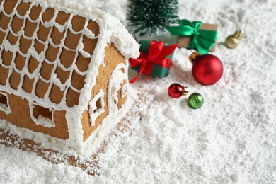 Beautiful gingerbread house decorated with icing and Christmas balls on snow