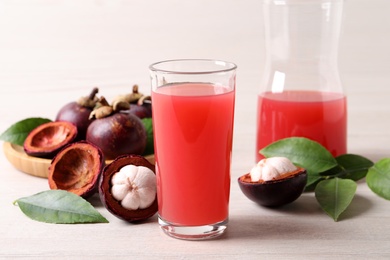 Delicious mangosteen juice and fresh fruits on white table