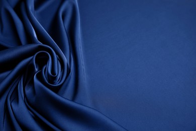 Crumpled dark blue silk fabric as background. Space for text