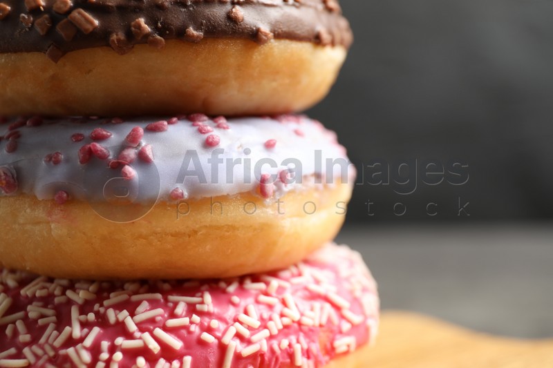 Delicious glazed donuts on grey background, closeup