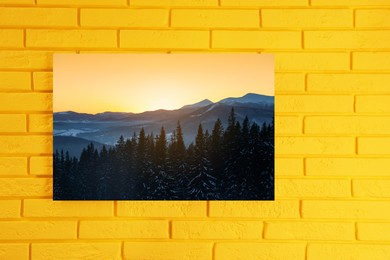 Canvas with printed photo of forest and mountain landscape on yellow brick wall