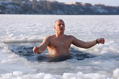 MYKOLAIV, UKRAINE - JANUARY 06, 2021: Man immersing in icy water on winter day