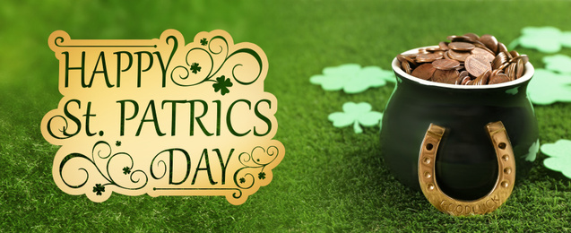 Pot of gold coins, horseshoe and clover leaves on green grass. St. Patrick's Day celebration