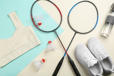 Flat lay composition with badminton rackets and shuttlecocks on color background