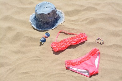 Jeans hat, sunglasses and bikini on sand. Beach accessories