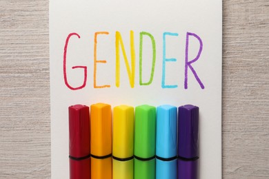 Notebook with word Gender and felt tip pens on wooden table, top view