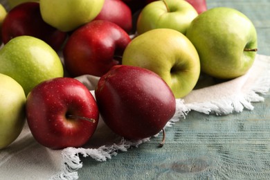 Photo of Fresh ripe red and green apples on light blue wooden table, closeup