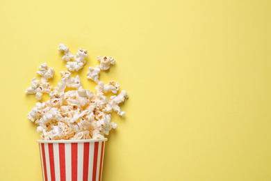 Delicious popcorn on yellow background, top view. Space for text