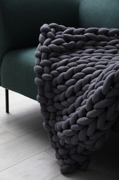 Soft chunky knit blanket on sofa indoors, closeup