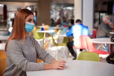 Woman with medical mask in cafe. Virus protection
