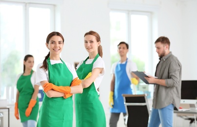 Team of professional janitors in uniform indoors