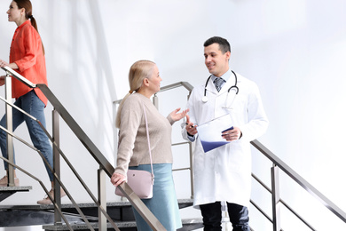 Doctor and patient discussing diagnosis on stairs in hospital