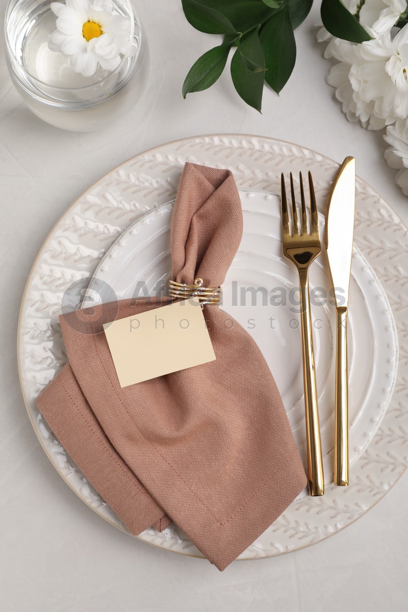 Elegant festive setting with floral decor on white table, flat lay