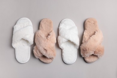 Different soft fluffy slippers on light grey background, flat lay