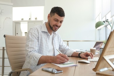 Freelancer working with computer at table indoors