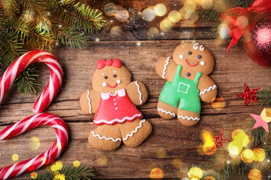 Flat lay composition with gingerbread couple on wooden table