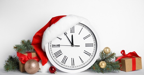 Photo of Clock and festive decor on white background. New Year countdown