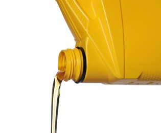 Photo of Pouring motor oil from yellow container on white background, closeup