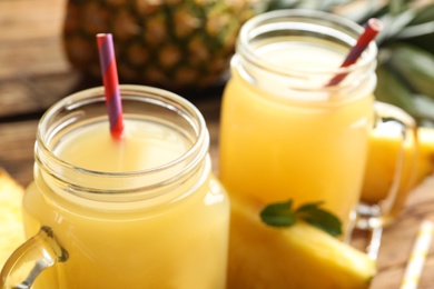 Photo of Delicious fresh pineapple juice on wooden table, closeup
