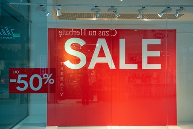 Photo of Siedlce, Poland - July 26, 2022: Sale sign on red stand in fashion store at shopping mall. Seasonal discount offer