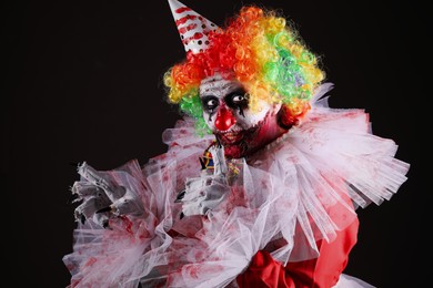 Terrifying clown on black background. Halloween party costume